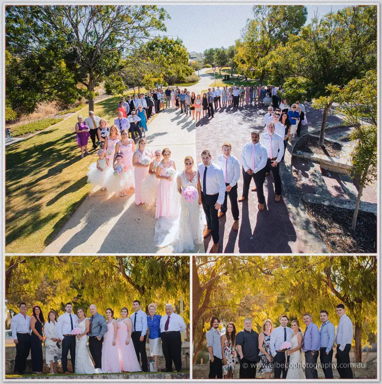 Tarmecca and Lee's full guest list lines the foreshore paths in sun while family groups pose below