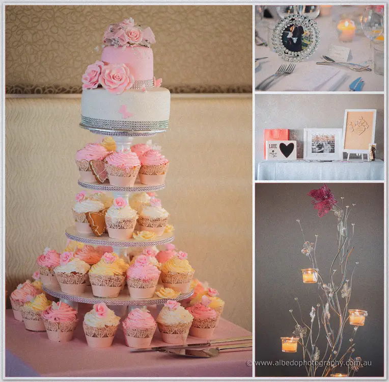 Pink rose tiered cake tower with cupcakes beside reception details: place cards, gift table and candelabra