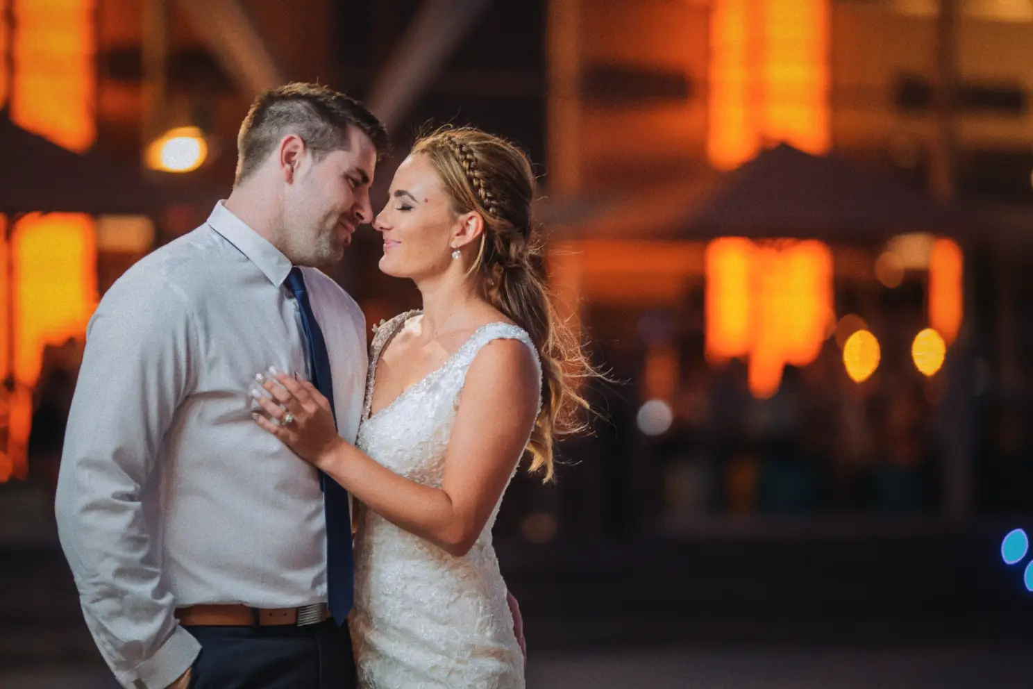 Nose to nose in the harbour night, Tarmecca's ring hand on Lee's chest amid warm orange lights
