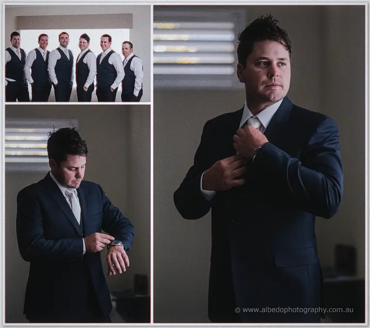 Michael adjusting his navy suit beside a window, groomsmen lined up ready in matching vests