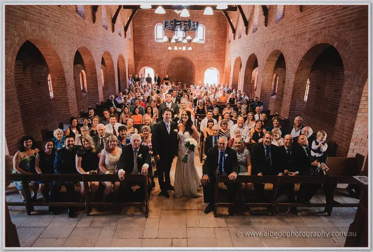 Prue and Michael with all their guests packed into the brick chapel for a group portrait