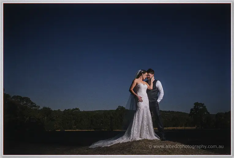 Prue and Michael alone on a rise at twilight, wrapped in a quiet embrace