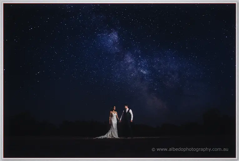 Prue and Michael holding hands beneath the Milky Way in a romantic night portrait at Fairbridge