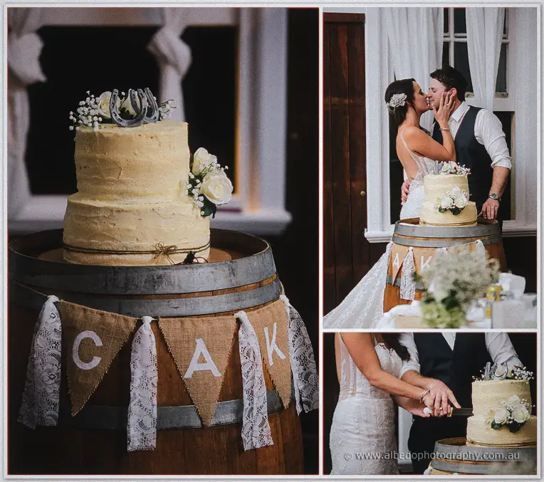 Prue and Michael cutting their buttercream cake on a wine barrel with a lace bunting