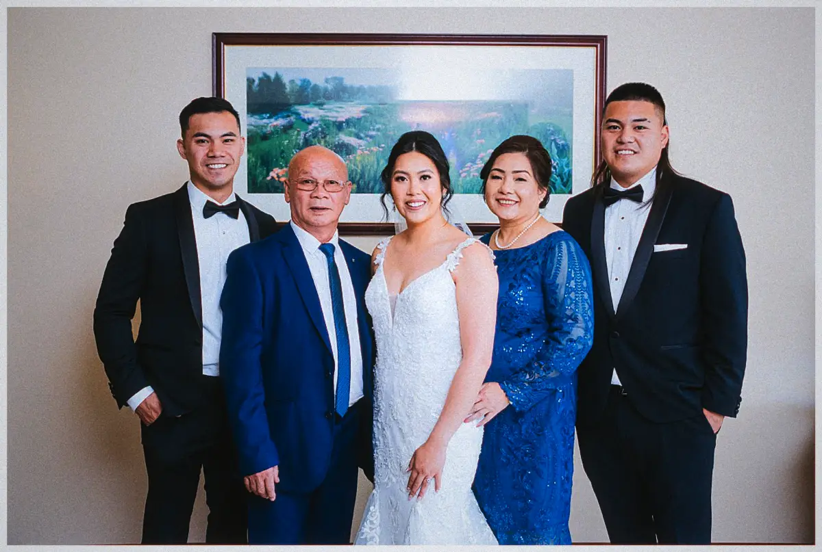 Natalie poses with her parents in blue and her brothers in tuxedos for a family portrait