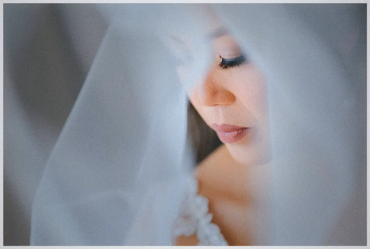 Natalie's eyes close softly behind the sheer veil in a dreamy close-up portrait