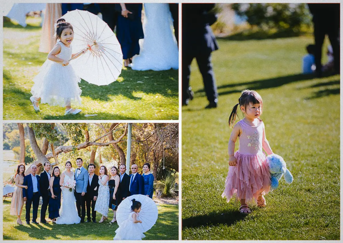 A flower girl twirls a paper parasol across the lawn as a toddler in pink tulle wanders past the family group