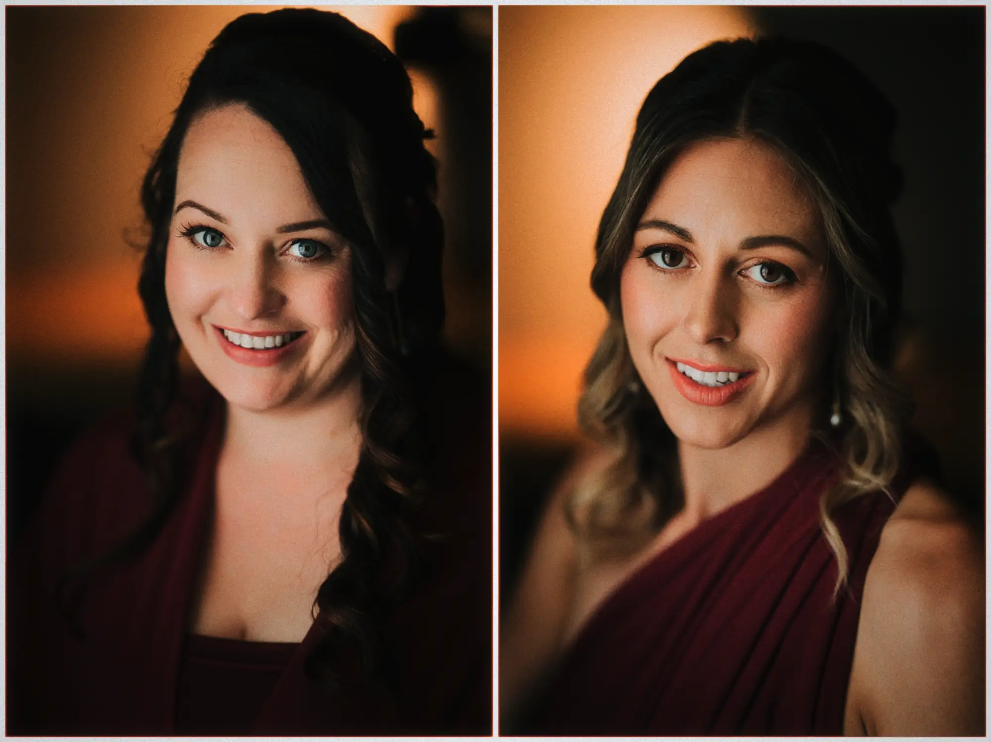 Two smiling bridesmaids with dark curls pose in burgundy gowns by warm window light.